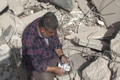 Depremzede gazeteci enkaz altında anılarını arıyor