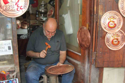 Türkü söyleyerek bakıra şekil veriyor